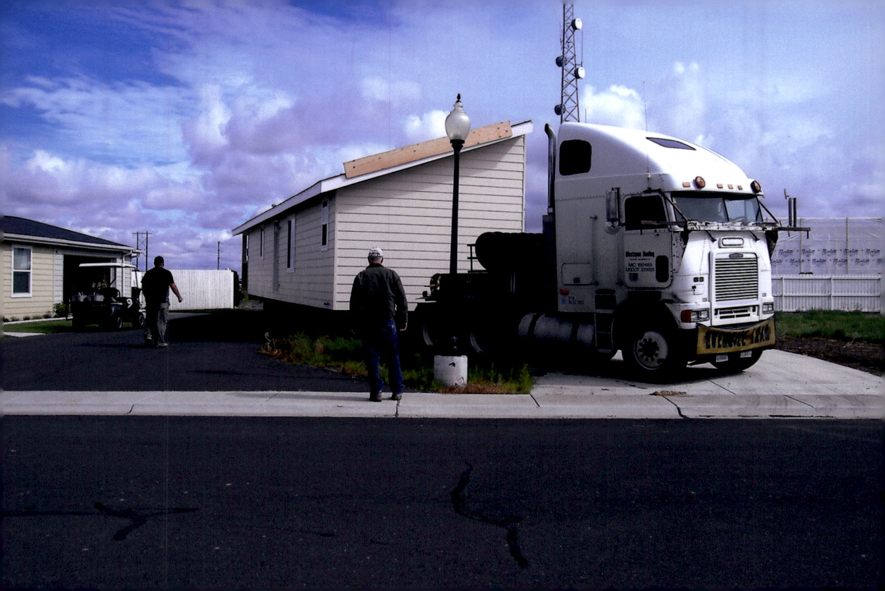 Efficient transportation of a manufactured home, expertly guided into its final placement.